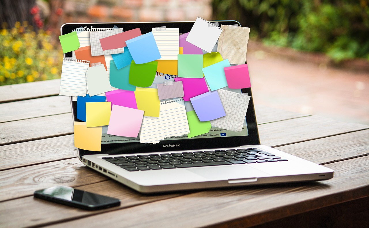 un laptop recouvert de post-it - Coach Leadership + stratégie d'affaires